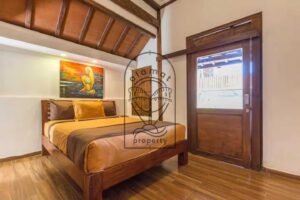 Villa Puri Kasa bedroom with teak bed, wooden ceiling and sliding door