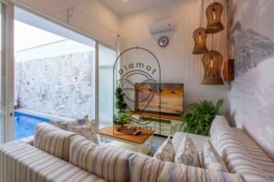 Air-conditioned lounge with pool view and floral cushions at Villa Jendaya