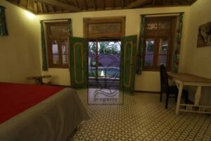 Villa Mizu bedroom with green carved doors opening to the pool