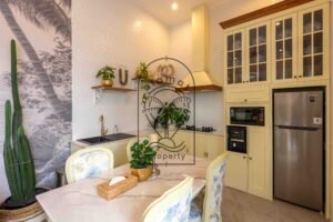 Cream kitchen with gas hob, fridge, microwave and marble table at Villa Jendaya