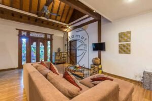 Villa Puri Kasa living room with sofa, carved doors and wooden ceiling