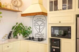 Microwave and water dispenser built into cream kitchen cabinets in Berawa