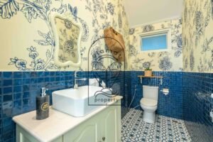 Guest toilet with blue floral wallpaper and blue mosaic tiles at Villa Jendari
