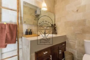 Villa Puri Kasa bathroom with wooden vanity and natural stone walls