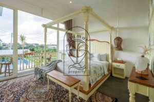 Four-poster bedroom with pool view and balcony at Villa Jendari in Berawa
