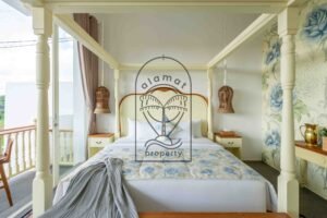 Four-poster bed with floral wallpaper, rattan lamps and balcony access in a Berawa villa