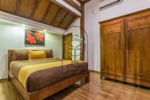 Villa Puri Kasa bedroom with hibiscus painting and teak wardrobe