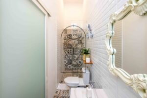 Ensuite bathroom with patterned tile shower and ornate mirror at Villa Jendaya