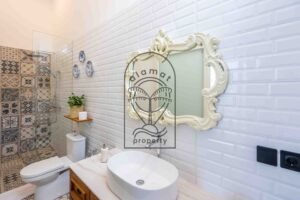 Bathroom with white metro tiles, marble vanity and rain shower in Berawa