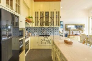 Equipped villa kitchen with glass cabinets, double-door fridge and marble island