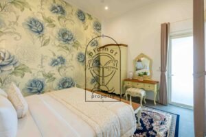 Bedroom with peony wallpaper, wardrobe and dressing table at Villa Jendari