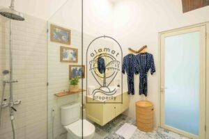 Ensuite bathroom with rain shower, bathrobes and cream vanity at Villa Jendari