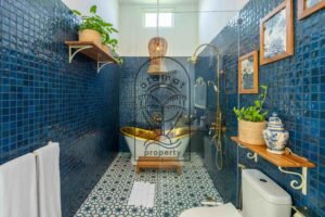 Luxury bathroom with gold freestanding bathtub and blue mosaic tiles at Villa Jendari