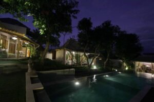 Villa Mizu pool and bungalows at night with Buddha statue